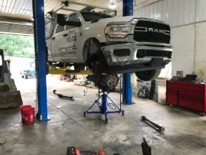 White pickup truck on a lift at GMK Mechanical in Morgantown, PA