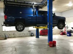 Large blue diesel pickup truck on a lift at GMK Mechanical in New Holland, PA