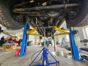 The underside of a pickup truck on a lift at GMC Mechanical in New Holland, PA