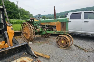 An old green tractor receiving mobile repairs by GMK Mechanical in Lancaster, PA